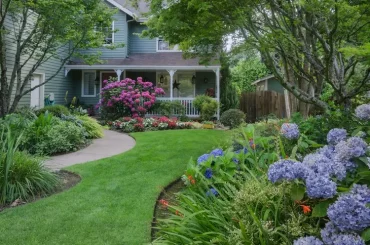 Üppige Vorgartengestaltung mit grünen und blühenden Gartenpflanzen