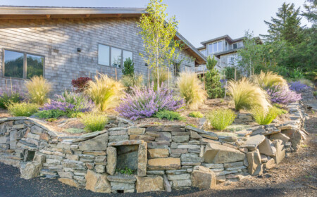 ziegräser wie elefantengras und lavendel als teil der gartengestaltung mit natursteinmauerwerk