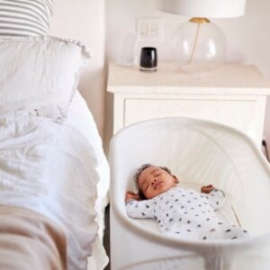 Baby schläft im Beistellbett im Schlafzimmer