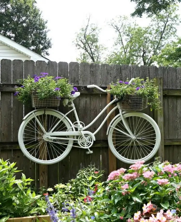 Ein altes Fahrrad als Blumenhalter am Zaun sieht toll aus