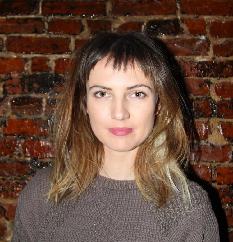 Shoulder-length hair with asymmetrical bangs lengthens the round face