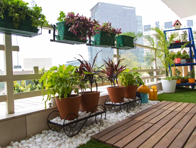 balkongarten in der stadt mit terrassendielen und blumentöpfen