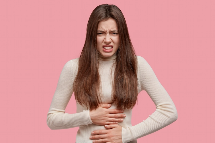young woman with stomach pain and symptoms of stomach inflammation