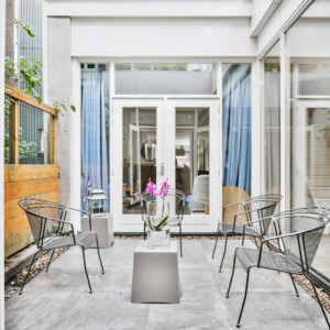 mehrere glastüren um kompaktem patio bereich in modern eingerichtetem innenhof eines hauses