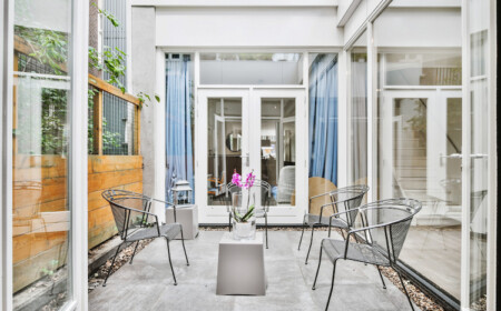 mehrere glastüren um kompaktem patio bereich in modern eingerichtetem innenhof eines hauses