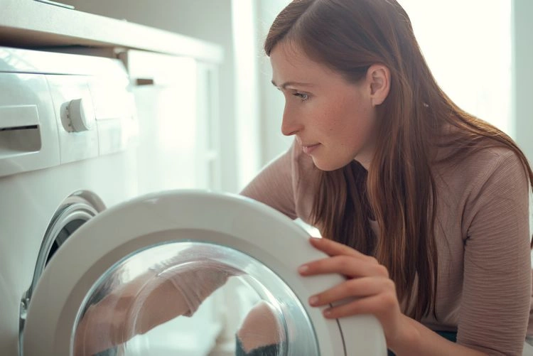 Bettwäsche vorsichtig aus der Waschmaschine nehmen