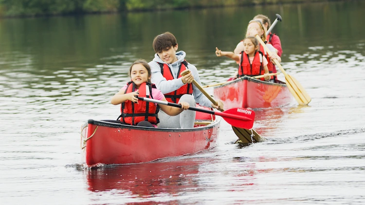 Sommerlager - Die Kinder steigen in ein Boot, Kajak oder Kanu und fahren die Spree hinauf