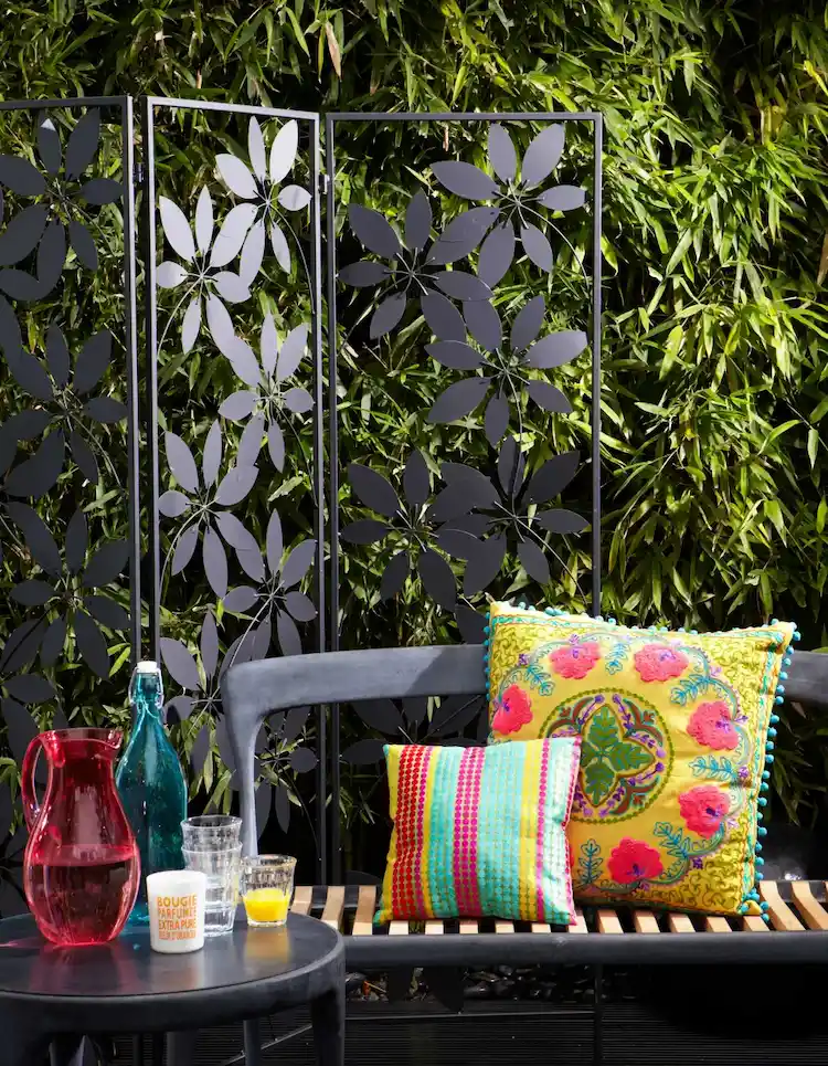 Ein Windschutz für Garten aus Metall mit floralen Details ist ein echter Blickfang