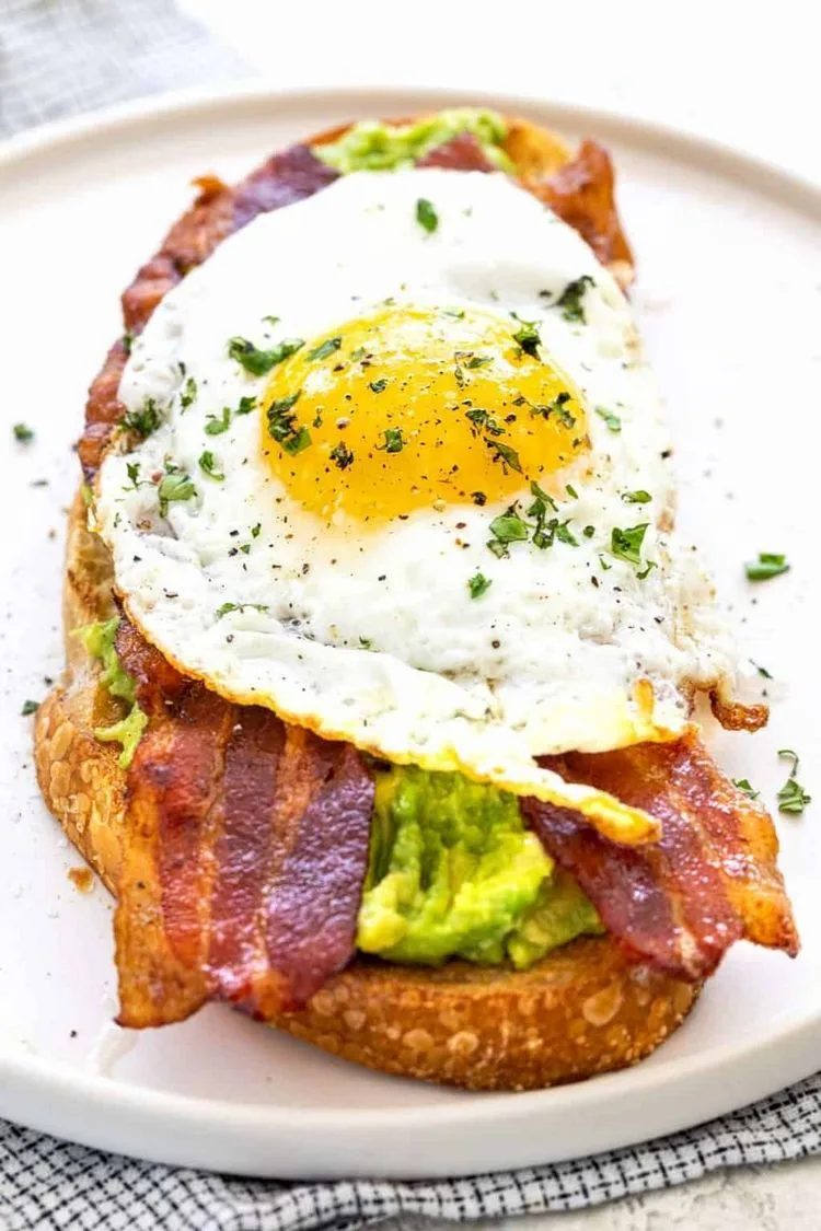Healthy breakfast bread mashed avocado fried egg bacon