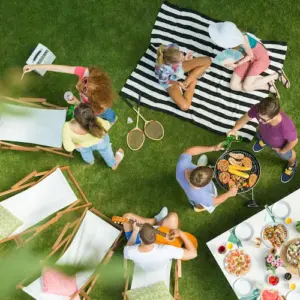 ansicht von oben auf eine grillparty im garten mit bunter tischdeko und liegestühlen