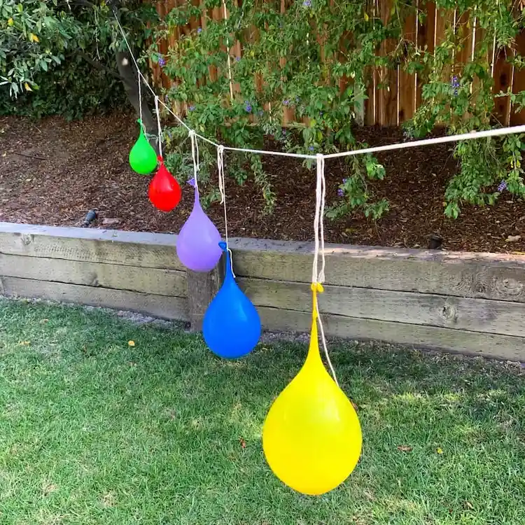 auf einem seil in reihe hängende wasserballons im garten bereit für spiele mit wasserbomben im sommer
