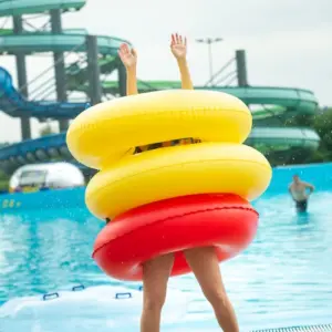 freude am pool mit schwimmringen während des sommers im erlebnisbad