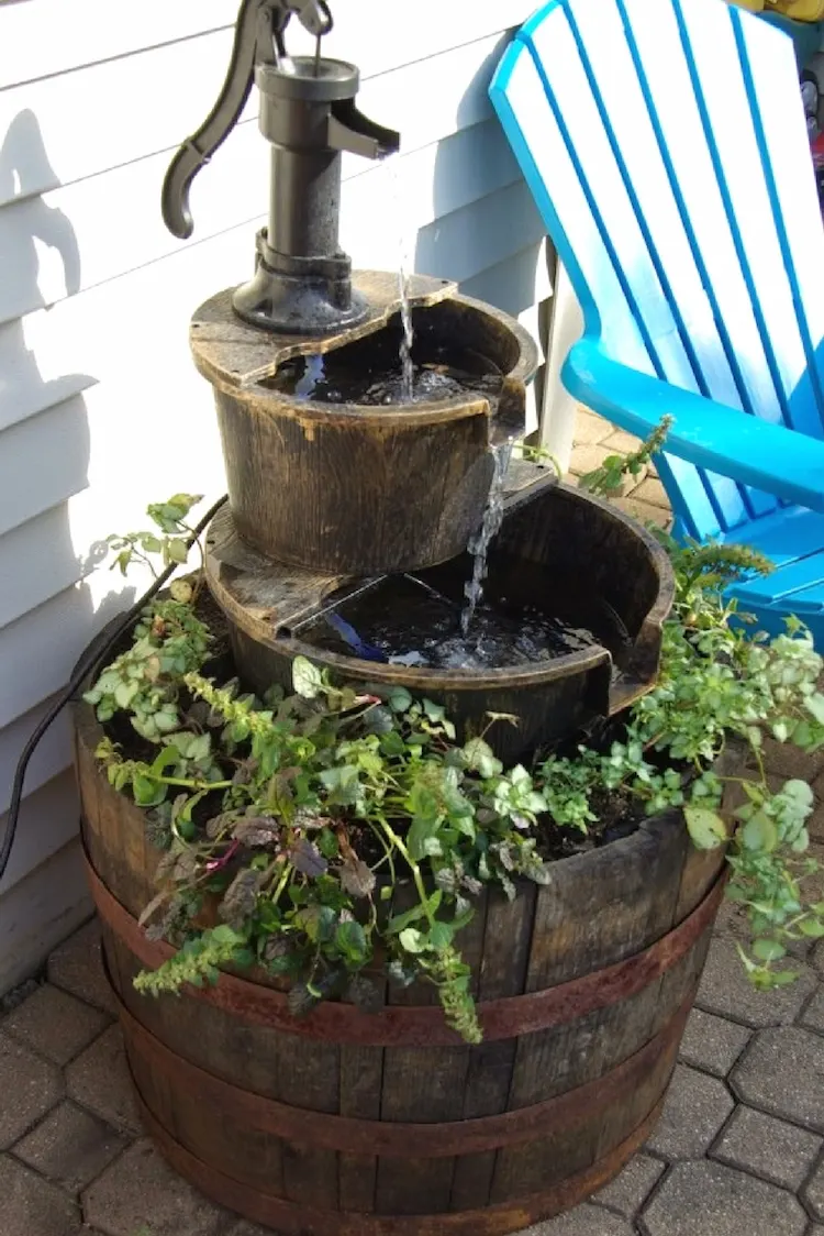 mit wasserbrunnen aus recycelten materialien wie fässern hinterhof oder gartenbereich verschönern