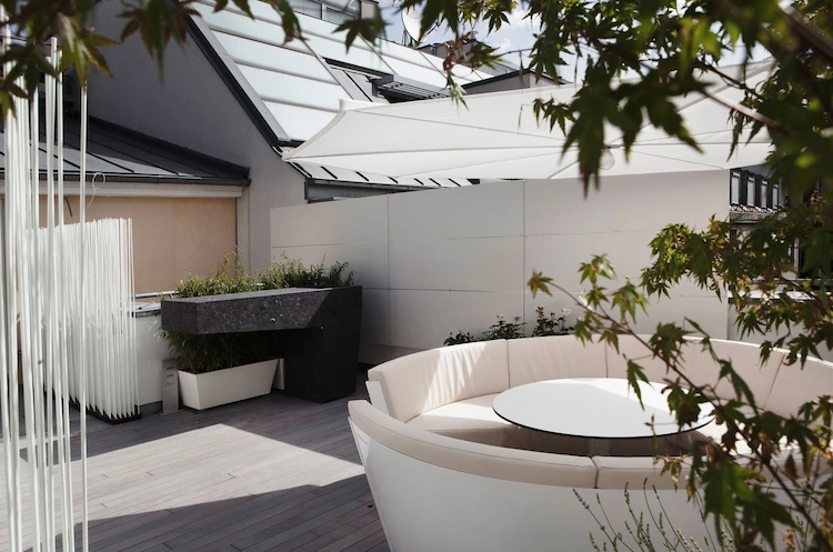 moderne terrassengestaltung mit runden gartenmöbeln und schattenspender in form eines schirms