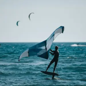 surfer im wasser verwenden einen flügel auf tragflächenboot namens wing foil