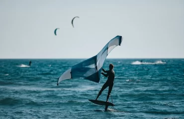 surfer im wasser verwenden einen flügel auf tragflächenboot namens wing foil