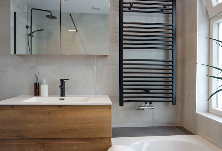 waschbeckenunterschrank aus holz in kombination mit schwarzen badearmaturen und heizkörper als moderne variante von badezimmer