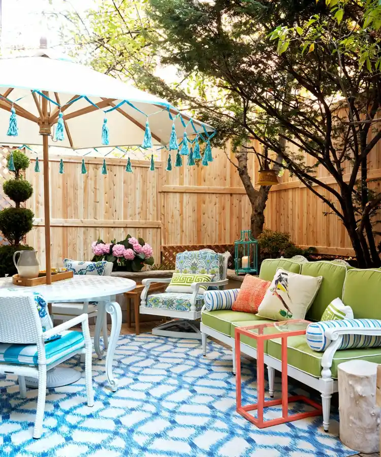 Farbenfrohe Sitzecke im Garten gestalten mit Sonnenschirm als Sonnenschutz und Teppich