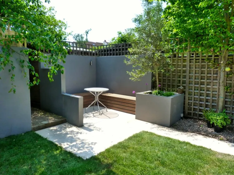 Moderne Sitzecke im Garten gestalten mit Beton, eingebauter Sitzbank und Kübel