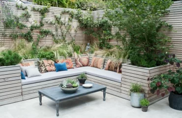 Moderne Sitzecke im Garten gestalten mit Holzleisten und Kletterpflanzen