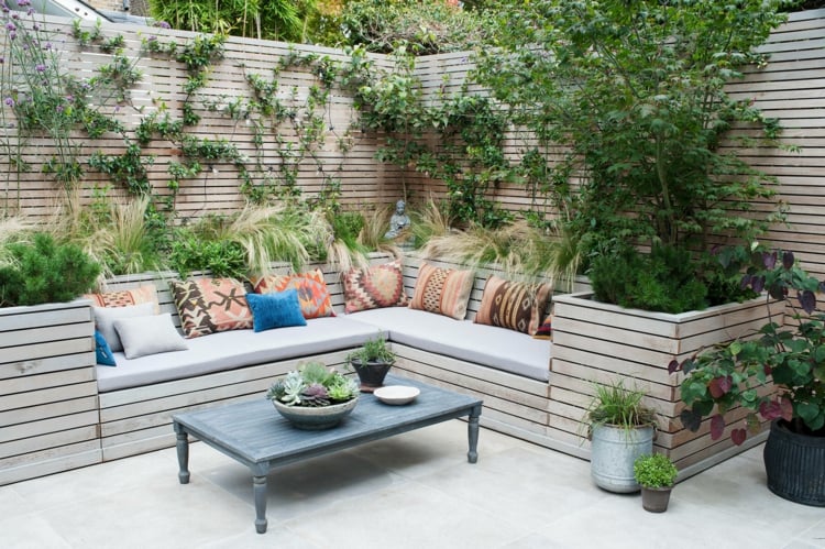 Moderne Sitzecke im Garten gestalten mit Holzleisten und Kletterpflanzen