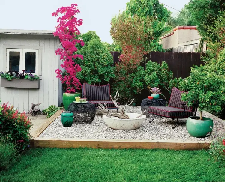 Sitzecke im Garten gestalten auf einem Kiesbett und Pflanzen im Hintergrund