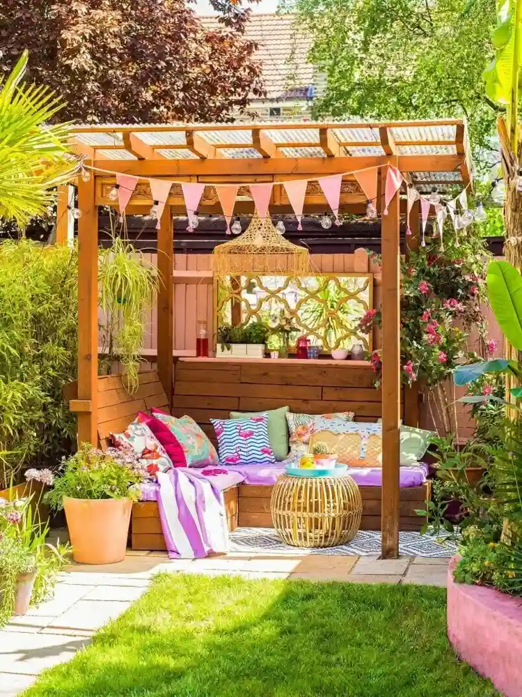 Sitzecke im Garten gestalten mit Überdachung aus Plexiglas und Textilien in bunten Farben