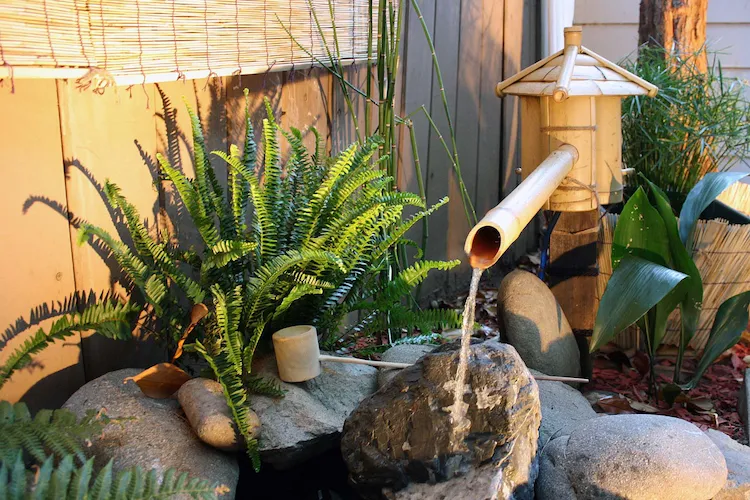 diy wasserspiel aus bambus und steinen schafft gemütliche atmosphäre in kleinem innenhof