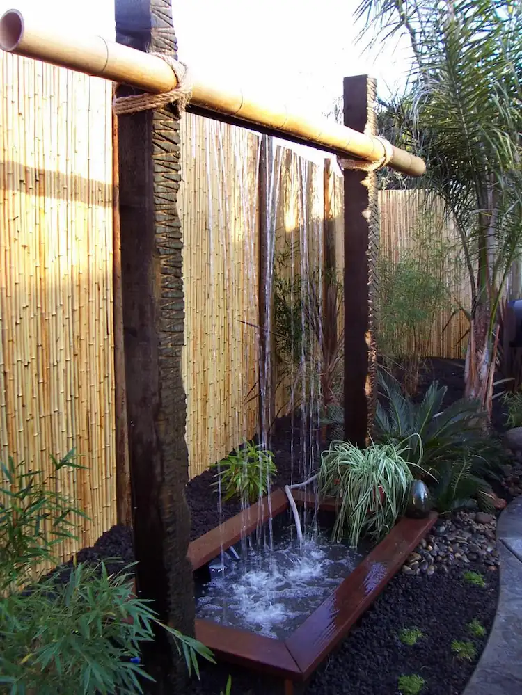 exotisches ambiente im hinterhof mit einem wasserfall brunnen und sichtschutz aus bambus schaffen