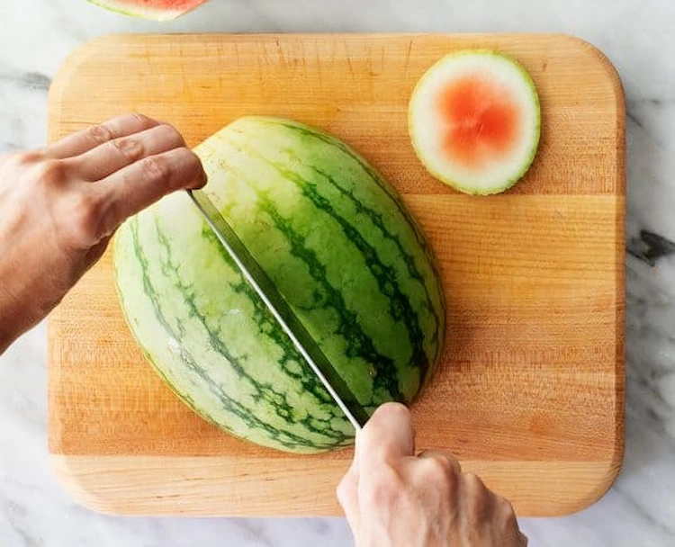 halbieren einer hälfte von wassermelone für weitere formen aus scheiben oder fruchtfleisch