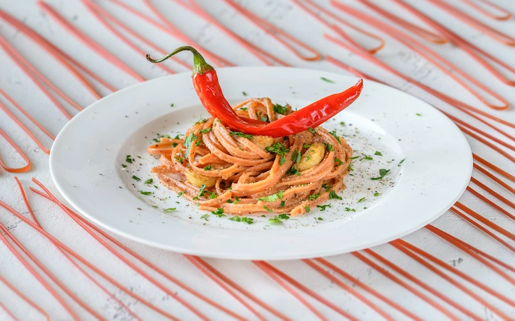 spaghetti aglio olio and peperoncino served on a plate, traditional Italian style