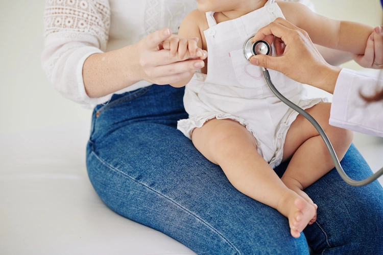kinderarzt untersucht kleines baby auf atemprobleme und herzfunktion