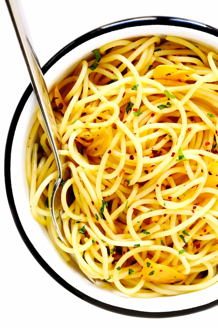 A delicious looking Italian dish is spaghetti aglio e olio with hot chili flakes and parsley