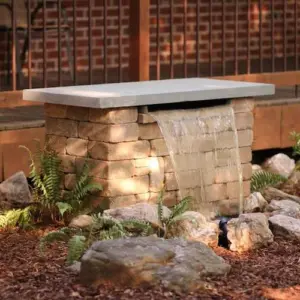 naturstein oder beton als materialien für den bau von brunnen mit wasserfall im garten verwenden