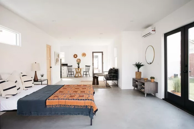 neutraler betonboden und weiße wände kontrastieren zu farbenfroh eingerichtetem schlafzimmer mediterraner stil