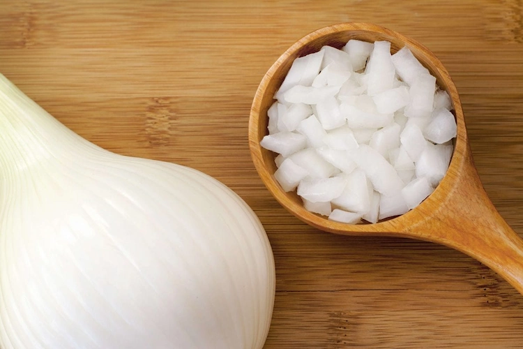 Um rohe Zwiebeln für die Trocknung vorzubereiten, schälen Sie sie und schneiden Sie sie in gleichmäßig dicke Scheiben oder Stücke