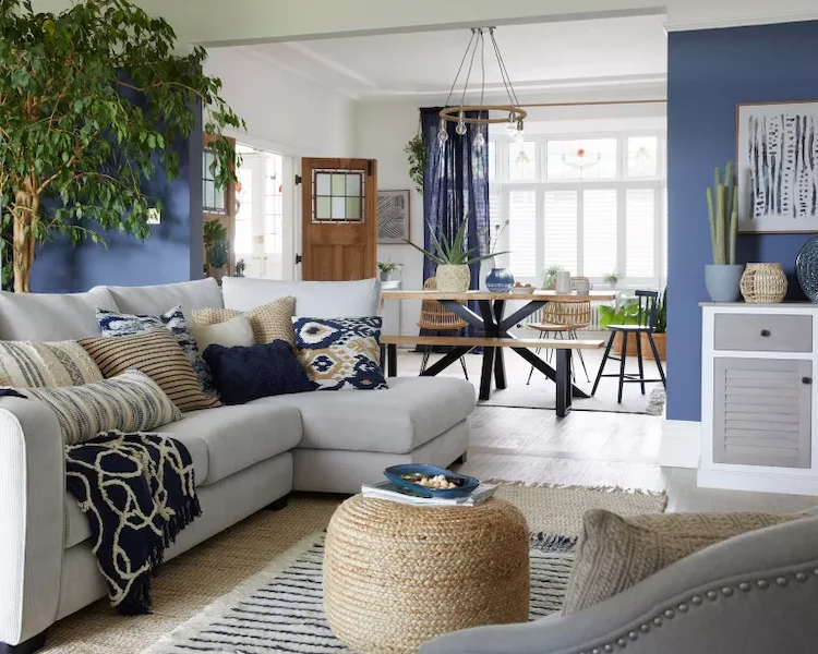 einladender wohnraum in einem strandhaus mit möbeln in sandfarben und meeresblauen wänden