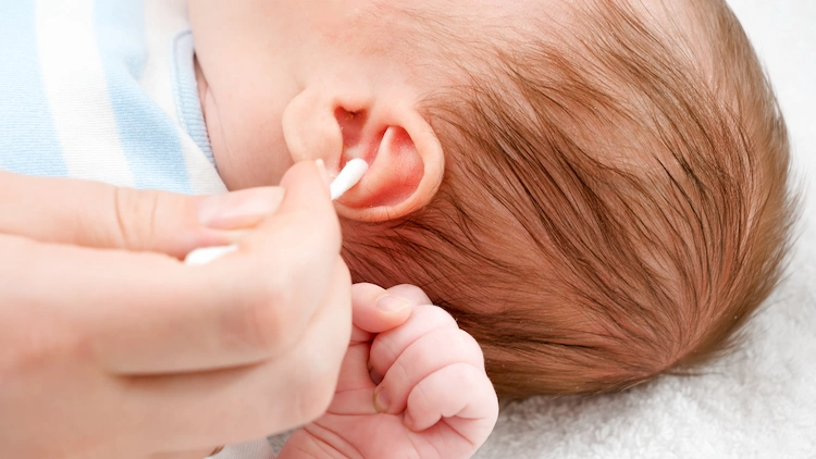 mutter benutzt wattestäbchen zum reinigen vom außenohr ihres babys