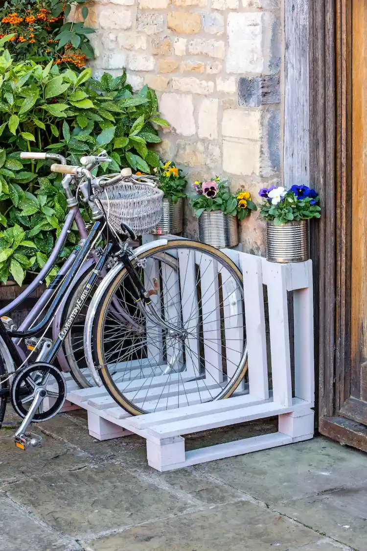 umweltfreundliche fahrradaufbewahrung mit paletten erstellen und mit blumen im gartenbereich gestalten