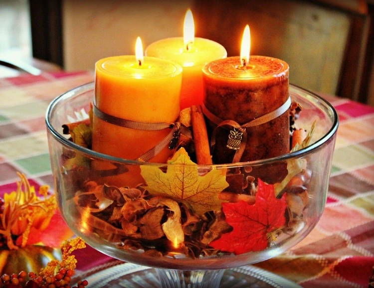 Glasschale mit Herbstlaub füllen und drei Stumpenkerzen arrangieren