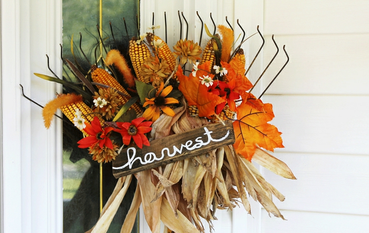 Herbstdeko für draußen mit einem Rechen und Kunstblumen