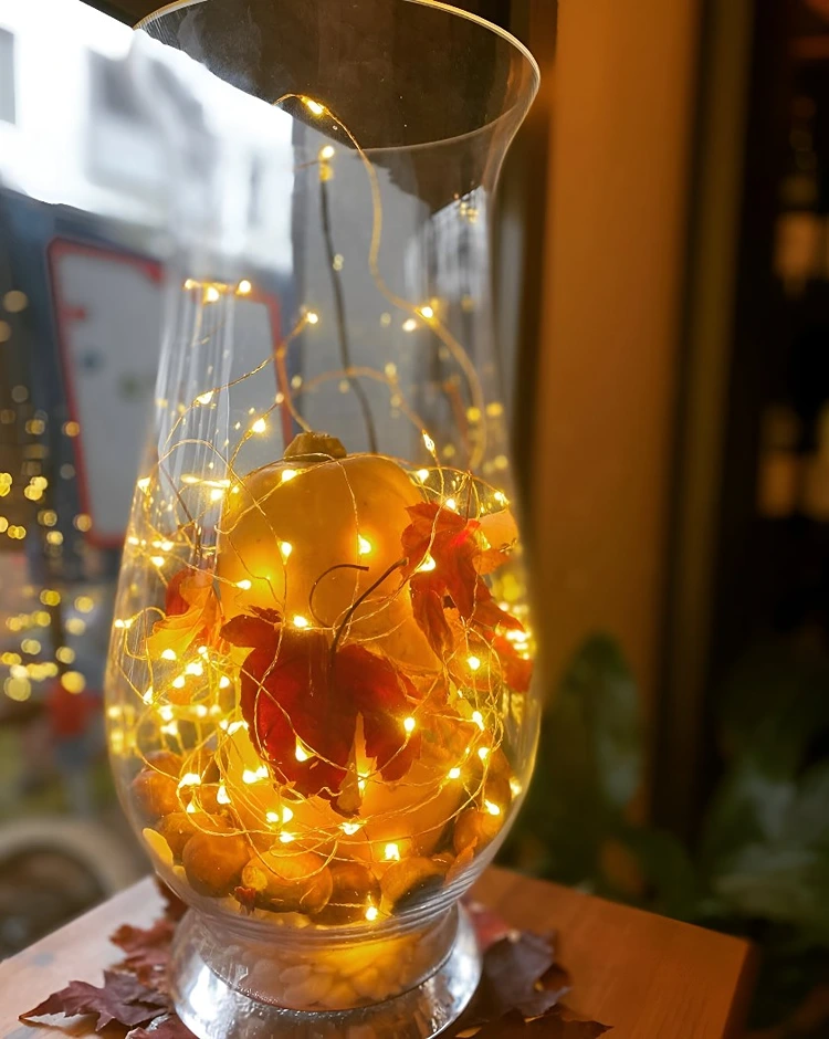 Dekoglas mit kleinem Kürbis und Lichterkette