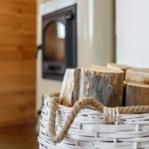 ein korb mit holzscheiten gefüllt und zum heizen mit holz durch kamin im winter gedacht