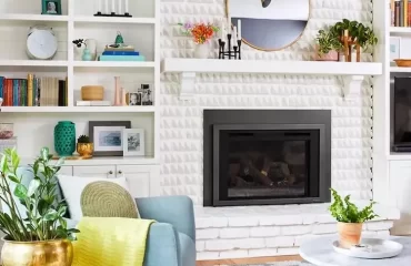 in weiß gehaltene wohnwand mit eingebautem sideboard mit kamin in einem wohnraum mit retro look