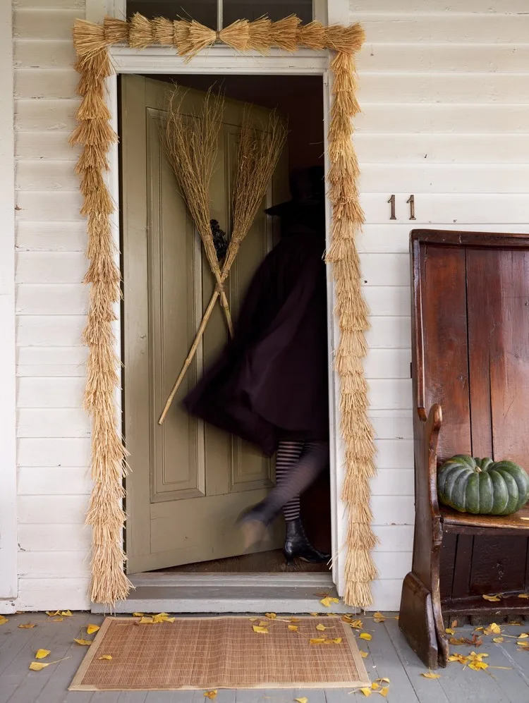 Besen bilden eine gruselige Halloween-Deko 2022 für die Eingangstür