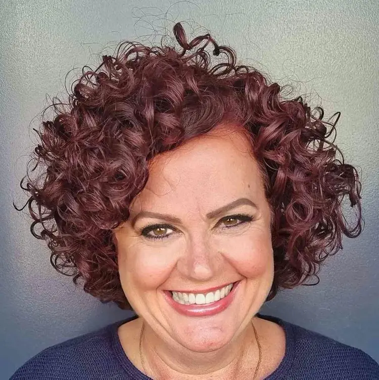 Kurze Locken und freche Haarfarbe für Frauen ab 60 mit rundem Gesicht