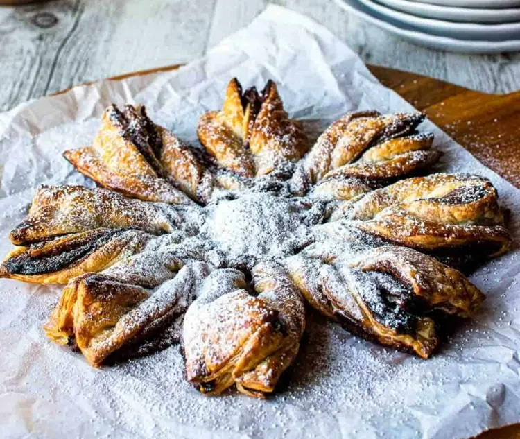 Nutella star made of puff pastry with powdered sugar or icing