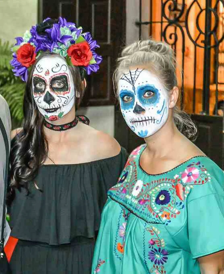 gesicht schminken am halloween 2022 nach mexikanischer tradition zum tag der toten mit bunten kleidern
