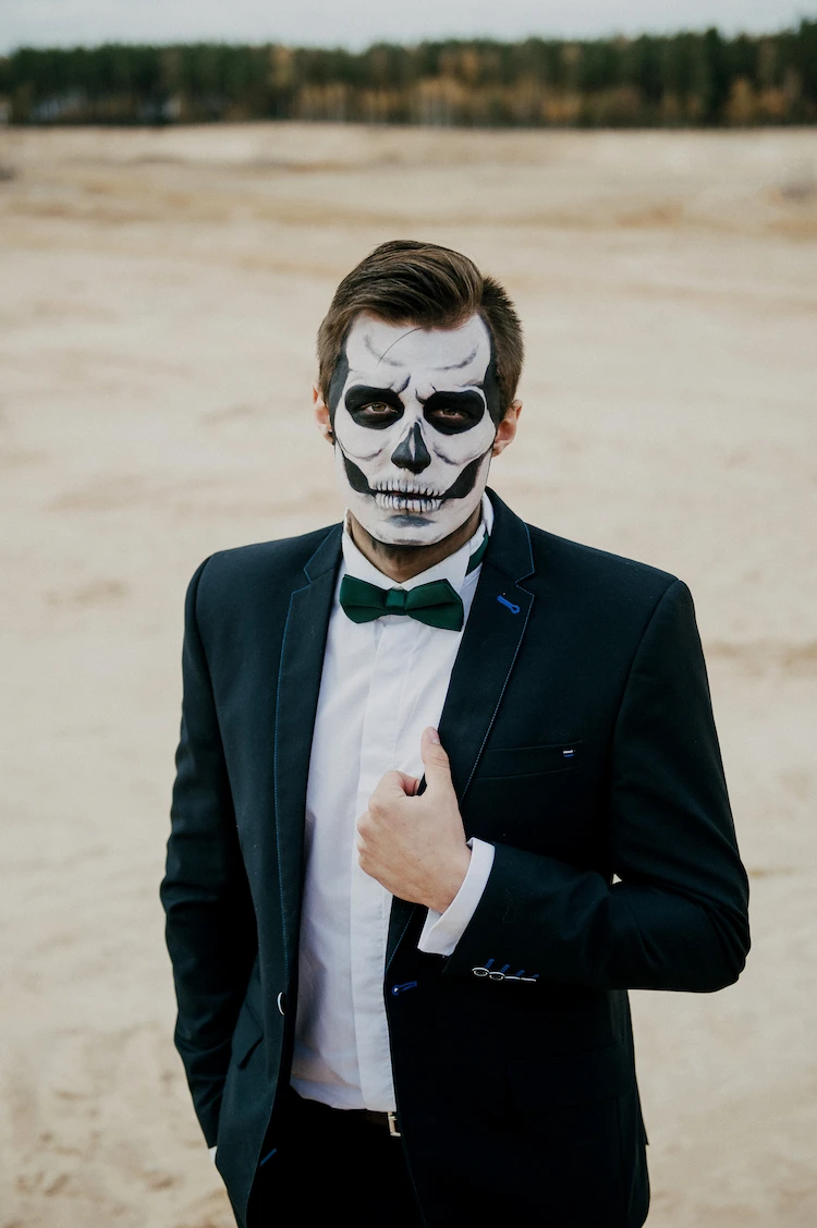 männerkostüm zum halloween mit elegantem anzug und schädel make up wie in mexiko