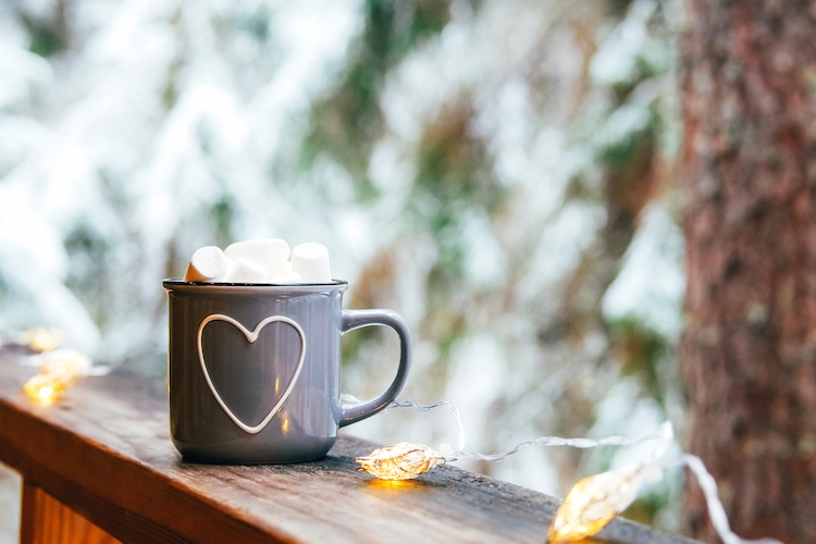 warmes getränk wie schokolade oder kaffee im winter auf der terrasse genießen